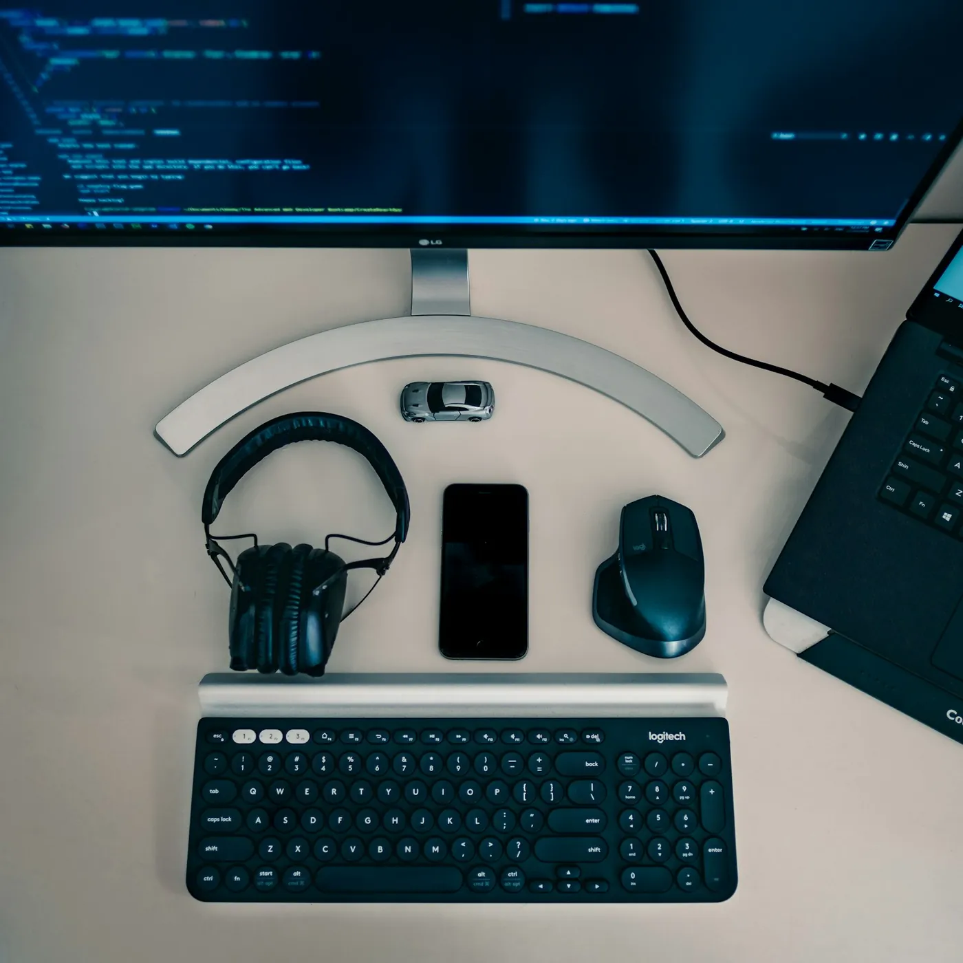 Headphones, keyboard, mouse and phone laid out on a desk