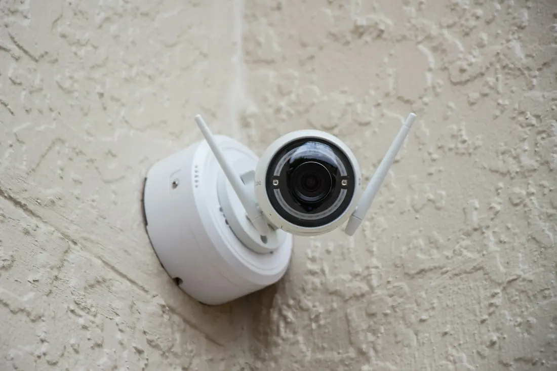 A white Wi-Fi security camera mounted on a wall