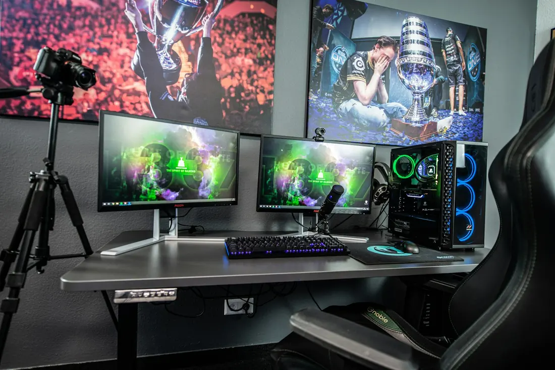 A gaming desk with two monitors and a PC tower